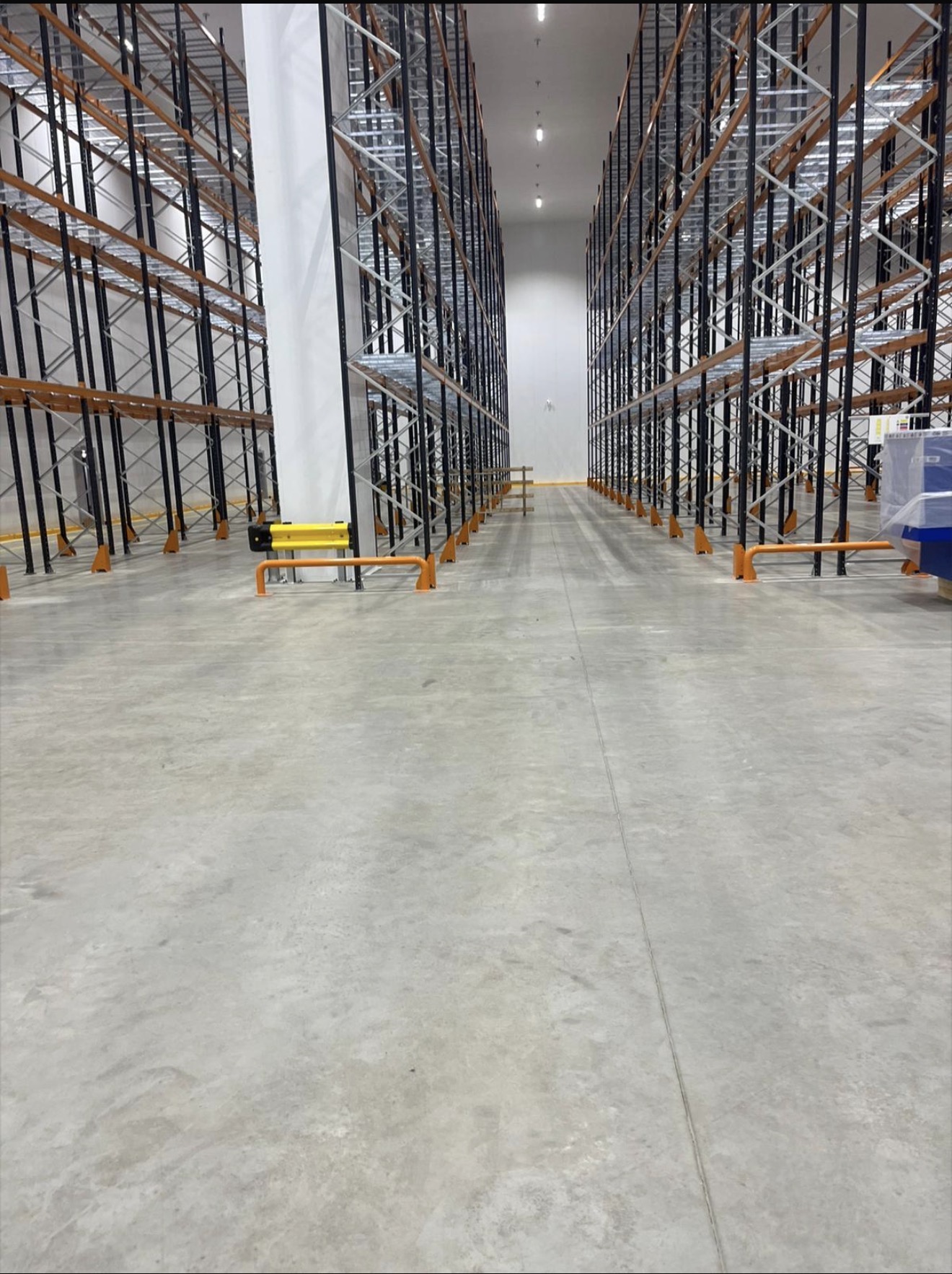 Large commercial warehouse interior with tall symmetrical racking