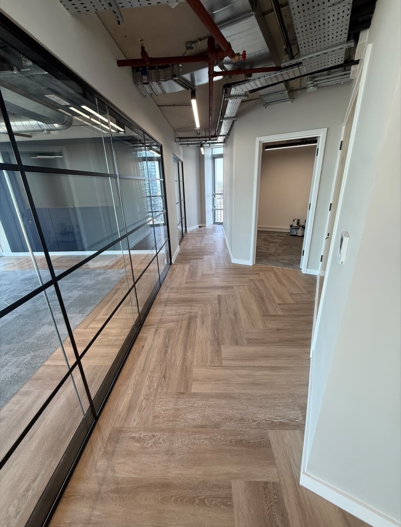 Completed commercial office corridor with glazed meeting rooms