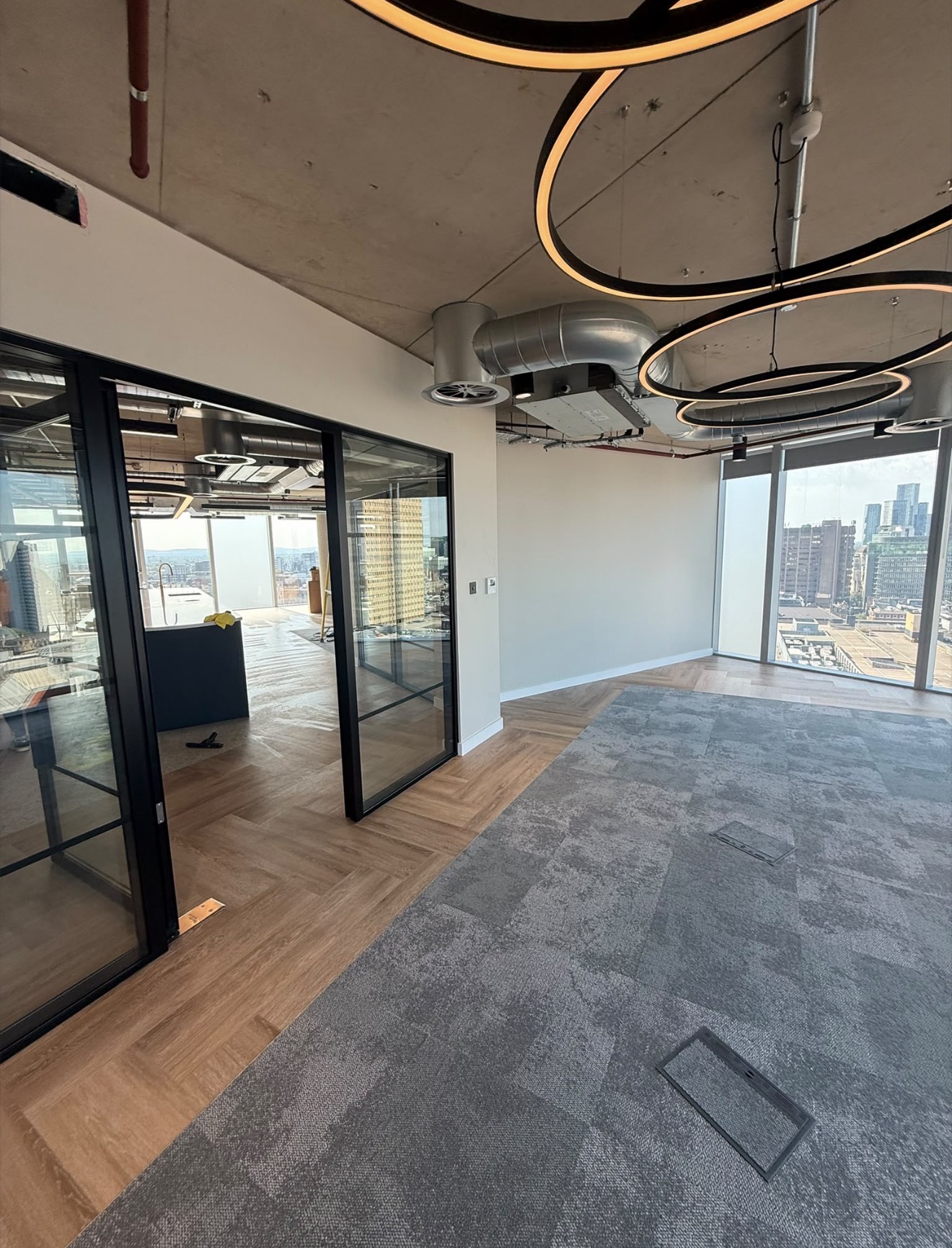 Completed modern commercial office interior with glass partitions and feature lighting