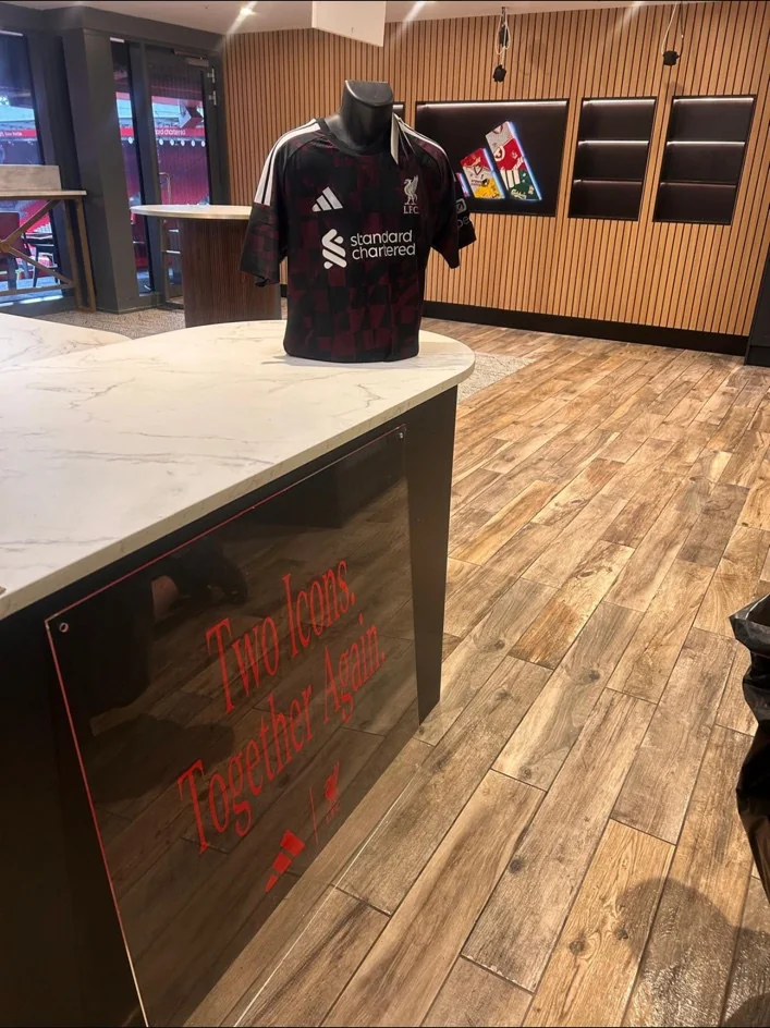 Counter, timber-effect flooring and display shirt in the New Adidas Lounge at Anfield